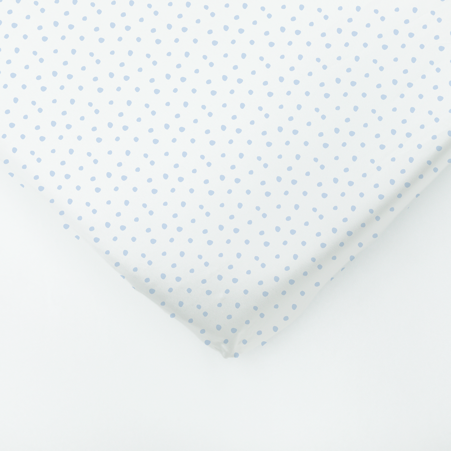 White silk fabric with a light blue polka dot pattern, shown in soft draped folds.